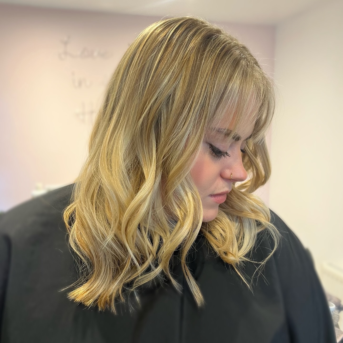 Bright blonde shoulder-length hair styled in soft waves
